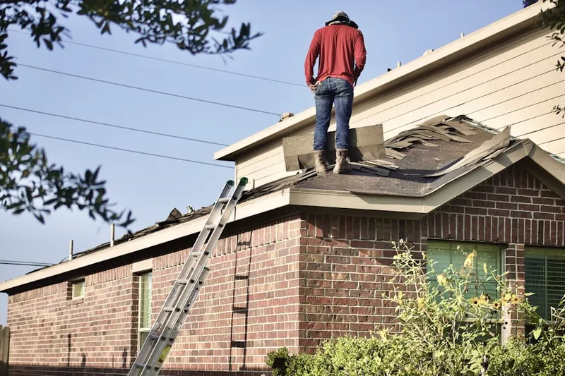 Professional roofer working on a residential roof in Williamsburg Estates